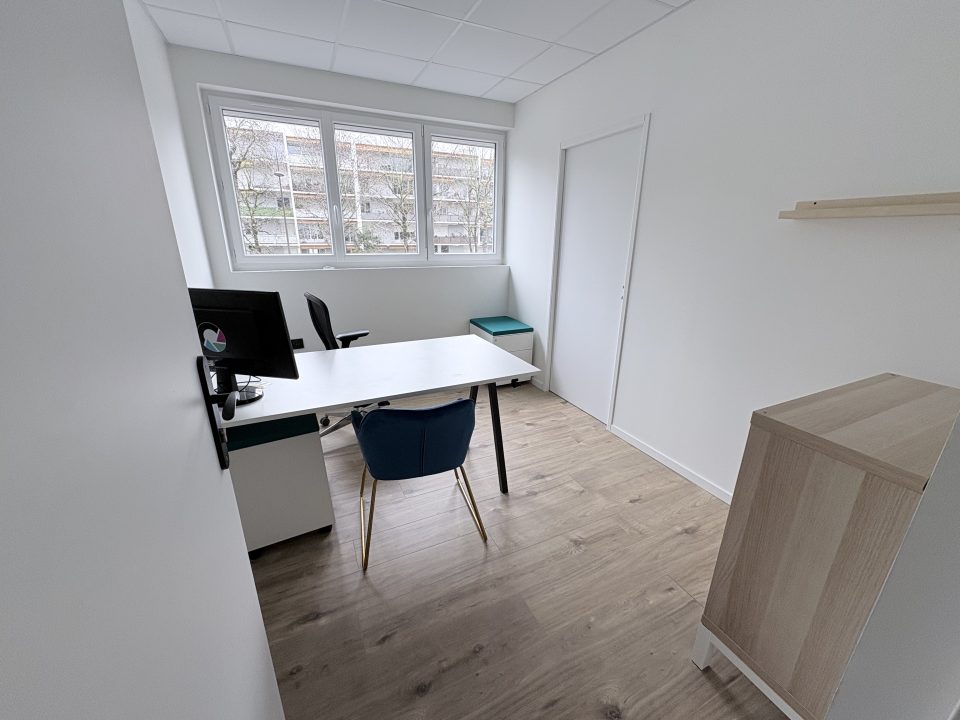 Bureau privatif avec écran, clavier, souris et chaise ergonomique dans un espace de coworking à Pau.